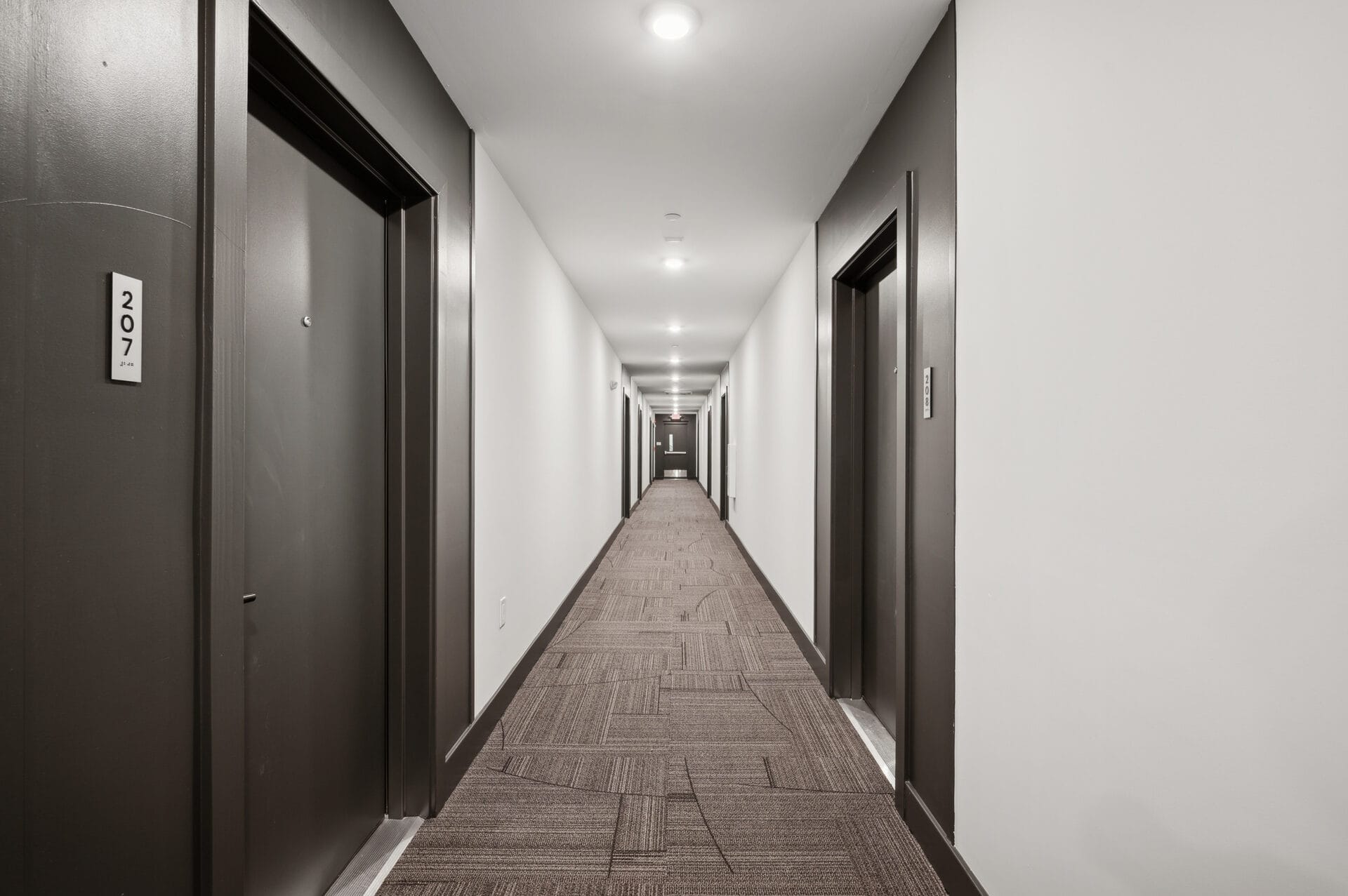 Residential corridor at The Lane Jenkintown with modern dark doors and patterned carpet